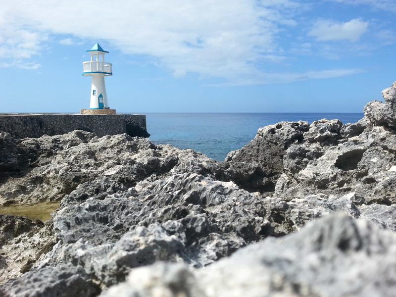 Coral in the foreground and a non-working lighthouse in the background. Negril Escape, Negril, Jamaica