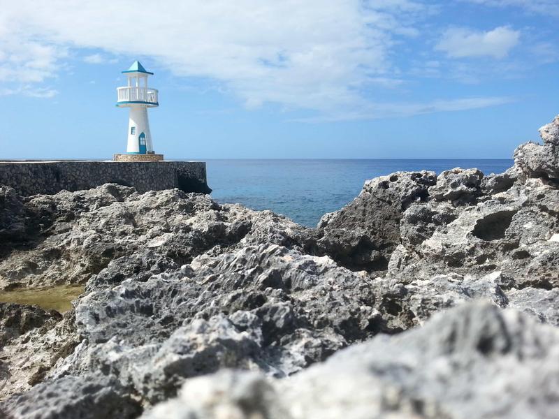 Coral in the foreground and a non-working lighthouse in the background. Negril Escape, Negril, Jamaica