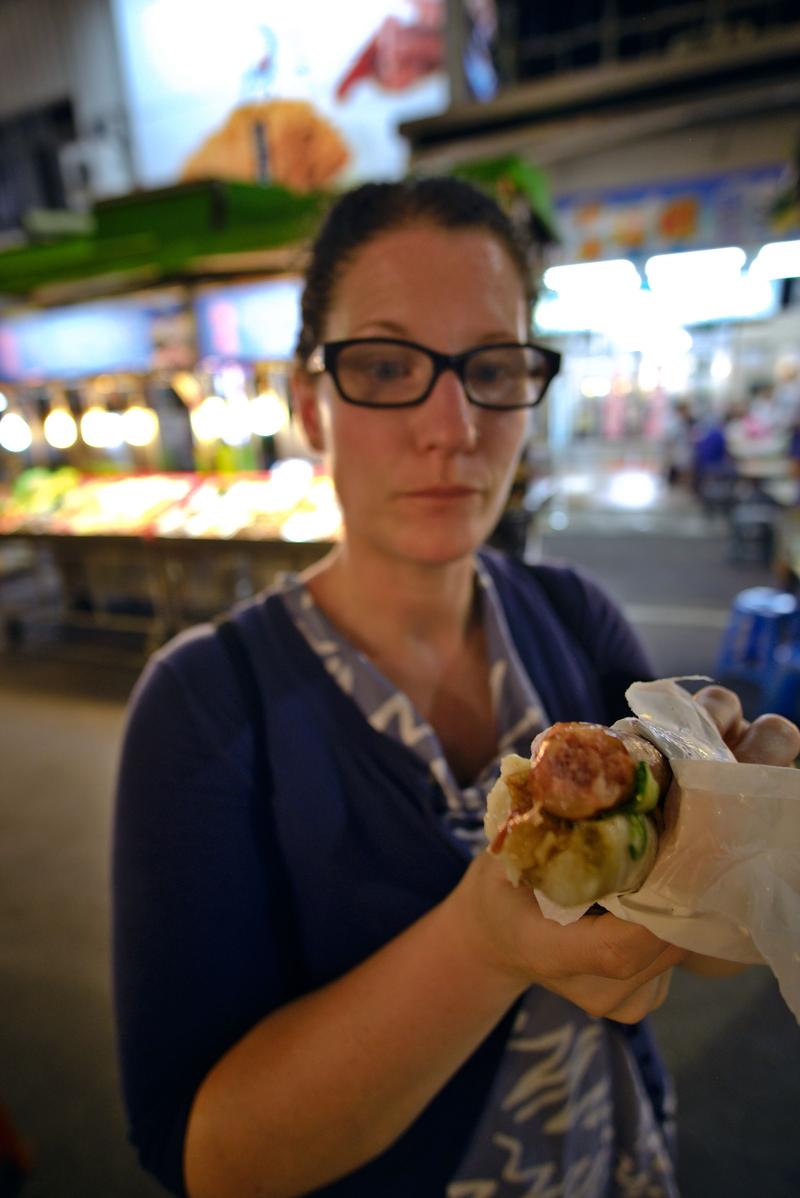 Trying a Taiwanese hot dog at Liuhe Night Market, Kaosiung, Taiwan