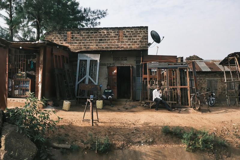 People hanging out in front of homes, Uganda