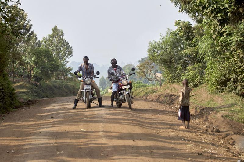 People on motorcycles on a dirt road, Uganda