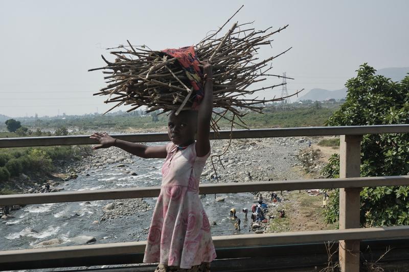 Kids carrying branch bundles on their heads, Uganda