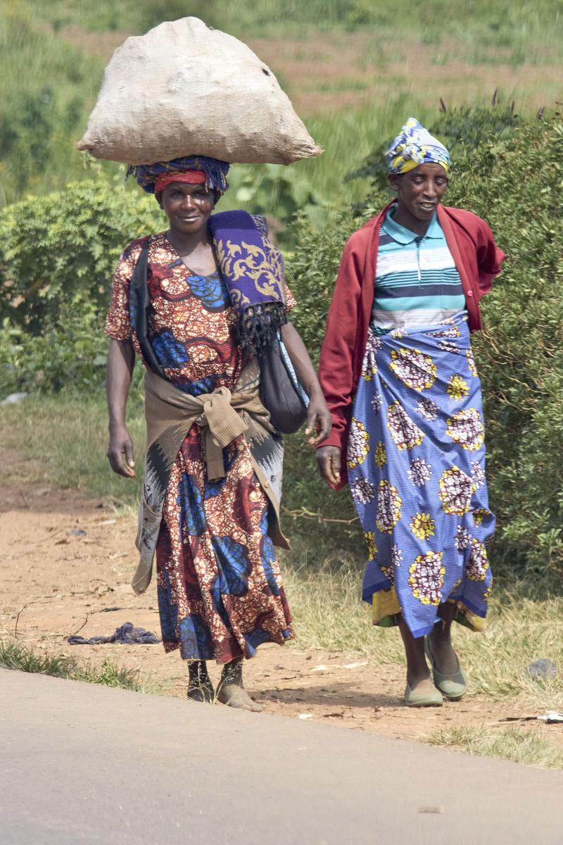 Women walking along the street, one with a bundle on her head, Uganda