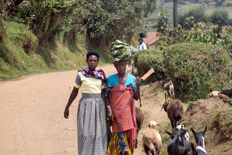Women walking along the street, one carrying a bundle on their head, Uganda