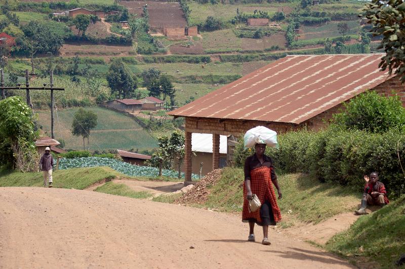 Woman walking along the street carrying a bundle on their head, Uganda