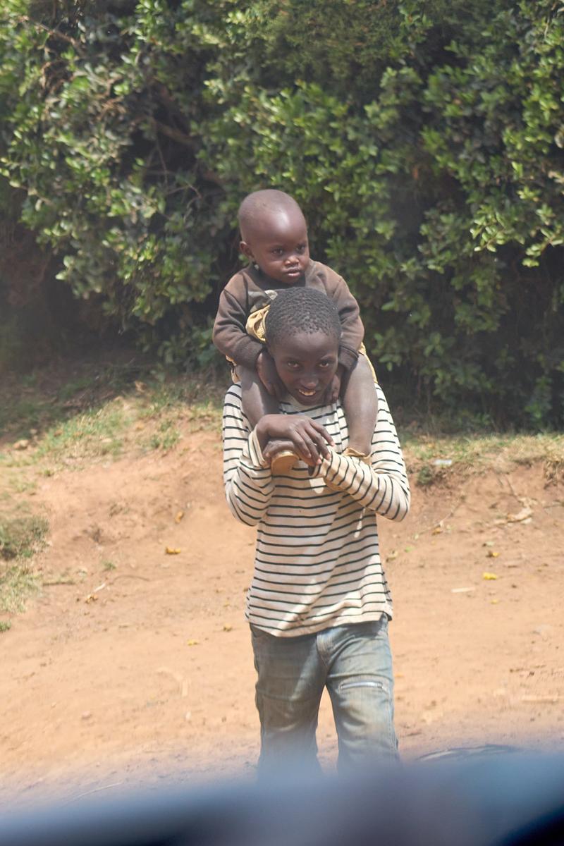 Kid carrying a smaller kid on their back, Uganda
